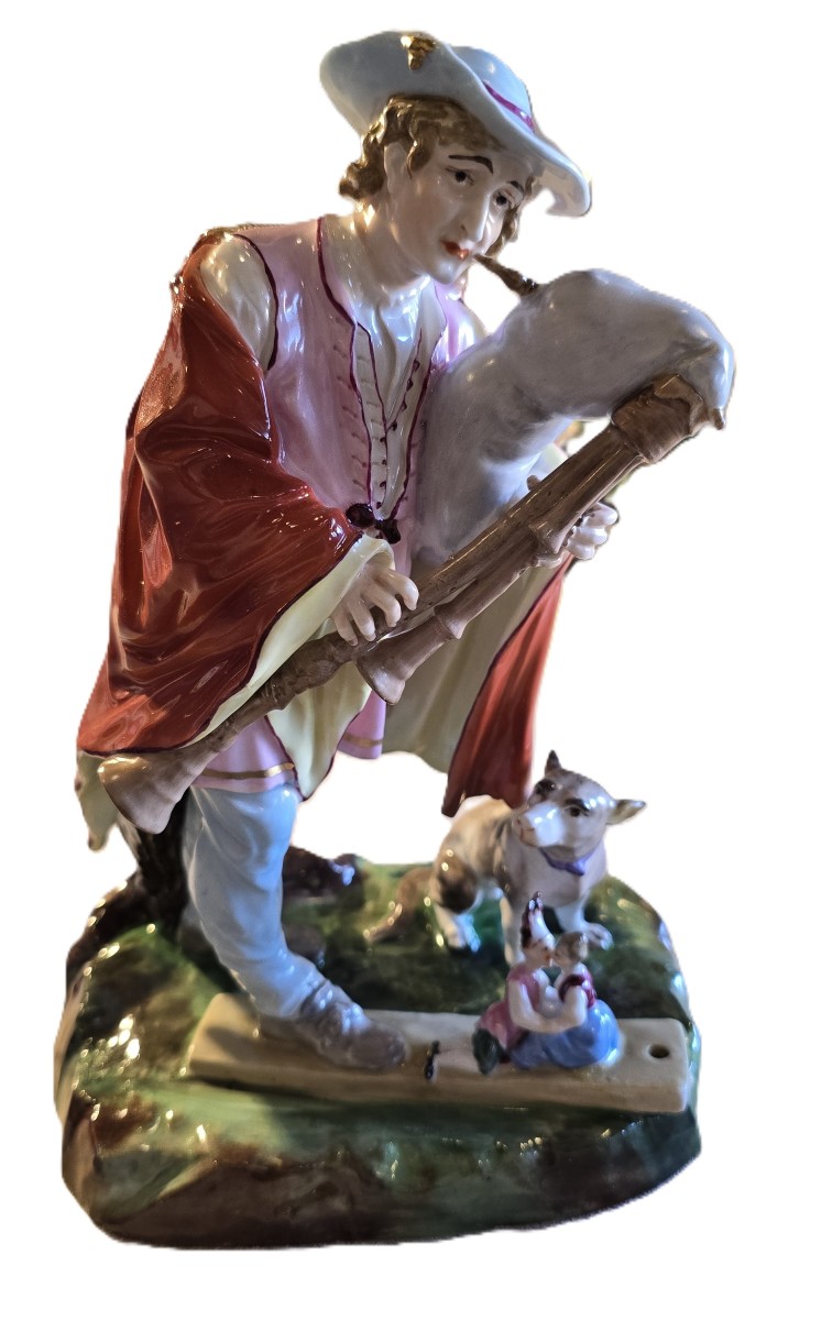 Gruppo in porcellana di Capodimonte raffigurante un suonatore di cornamusa e le sue marionette
