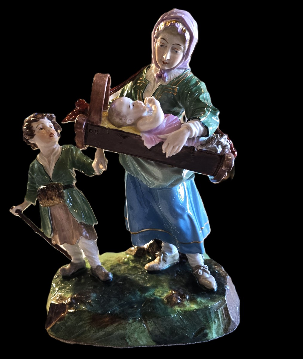 Gruppo in porcellana Capodimonte raffigurante mendicante,  bambino e un neonato nella culLa