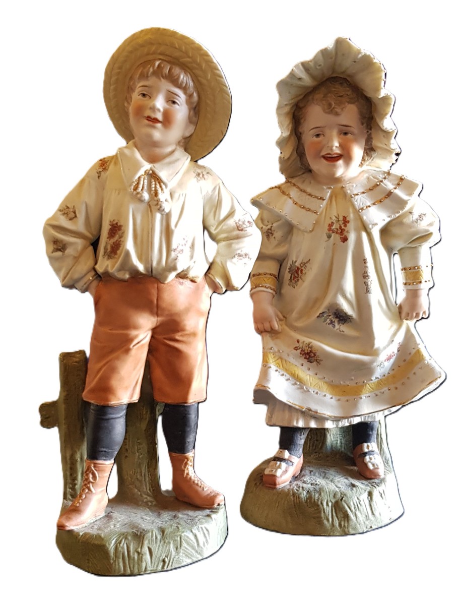 Coppia di antiche statuine in biscuit, bambini vestiti da contadinelli