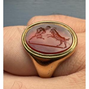 A 18k Signet Ring Set With A Grand Tour Carnelian Intaglio. Pan Fighting A Goat.