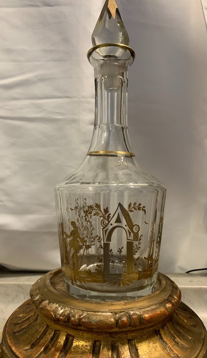 Una bottiglia-decanter in vetro molato e dipinto d'oro.