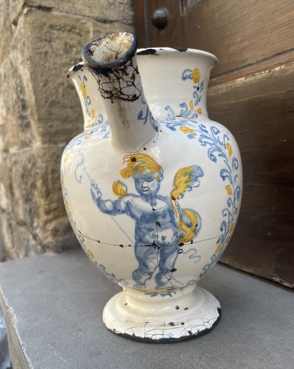 Versatoio in maiolica decorata a mano, con amorino e motivi vegetali. Faenza? Fine XVII secolo 
