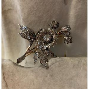 Una spilla a forma di un rametto con i fiori con diamanti antichi oro e argento. XIX secolo.