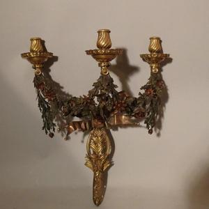 Coppia di appliques a tre fiamme in bronzo dorato e fiori in lamierino policromato