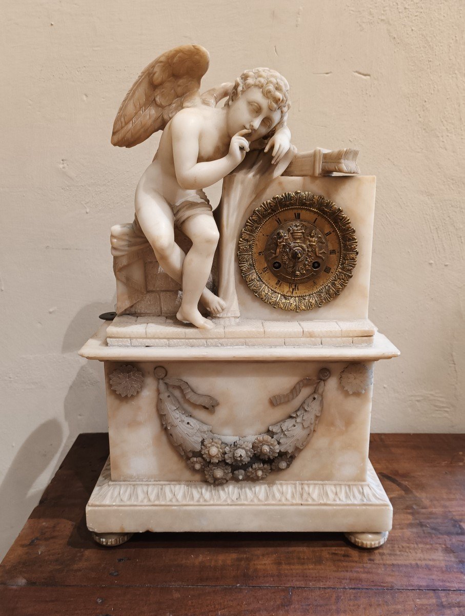 Orologio in alabastro scolpito con putto. XIX secolo,