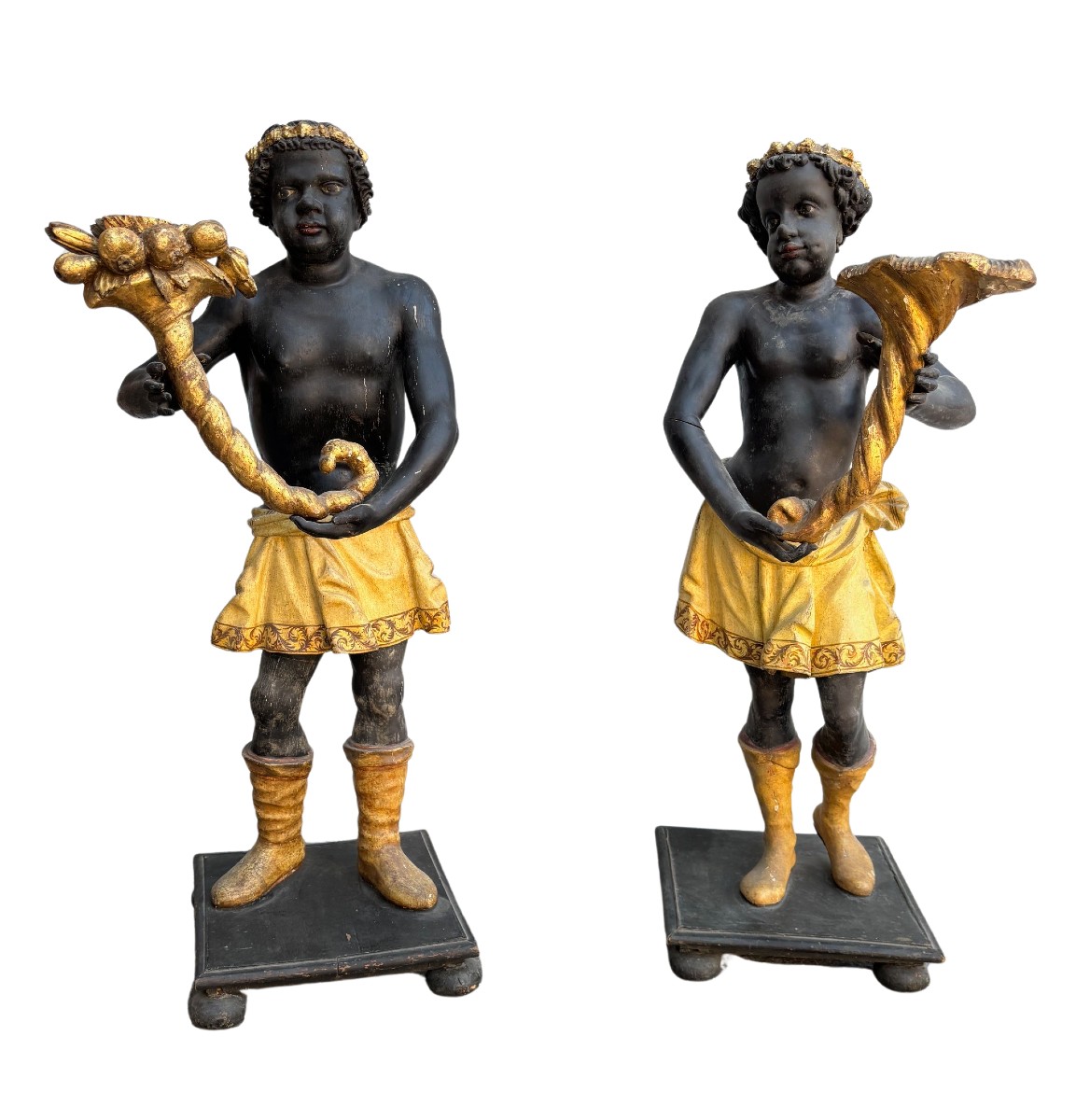 Coppia di sculture raffiguranti moretti in legno laccato e dorato