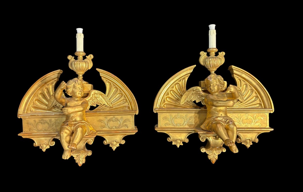 Coppia di sculture raffiguranti angeli in legno intagliato e dorato