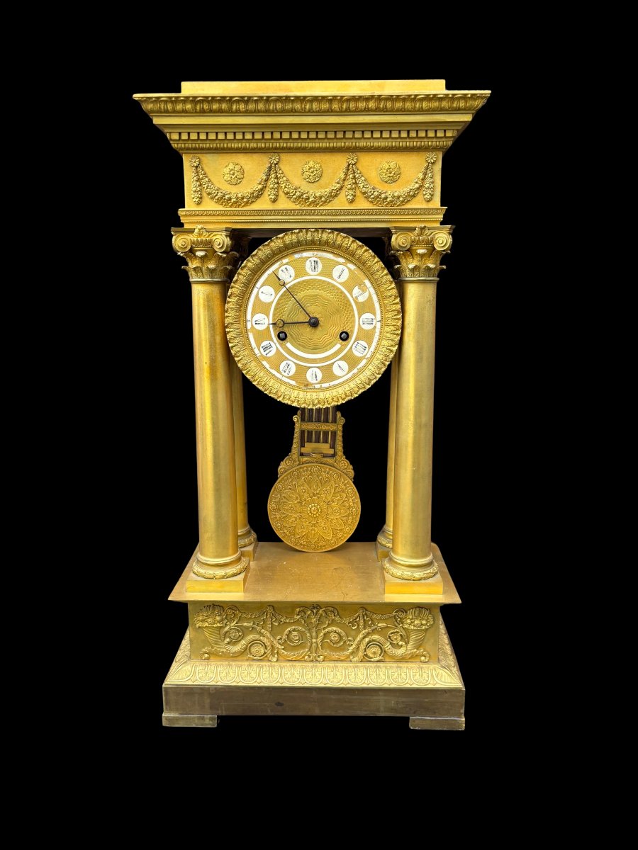 OROLOGIO A PORTICO IN BRONZO DORATO DI EPOCA IMPERO.