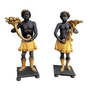 Coppia di sculture raffiguranti moretti in legno laccato e dorato