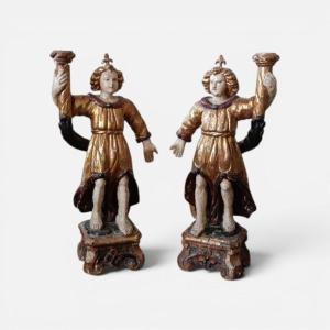 Antica coppia di angeli reggicandela antichi, realizzati in legno intagliato, laccato e dorato