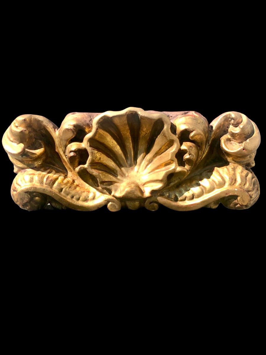 Mensola-applique in legno intagliato e foglia oro con decoro rocaille e conchiglia.