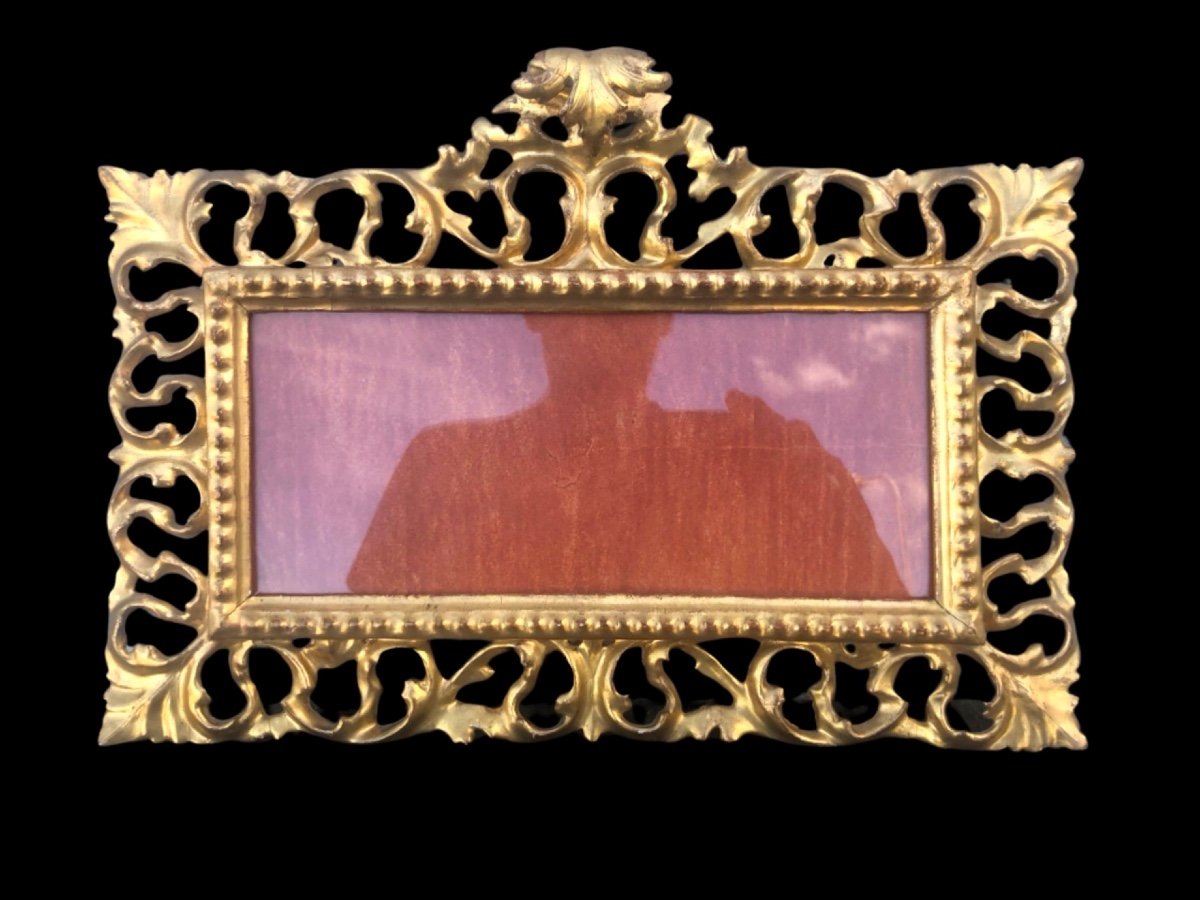 Cornice rettangolare a cartoccio in legno intagliato,traforato e foglia oro.Firenze.