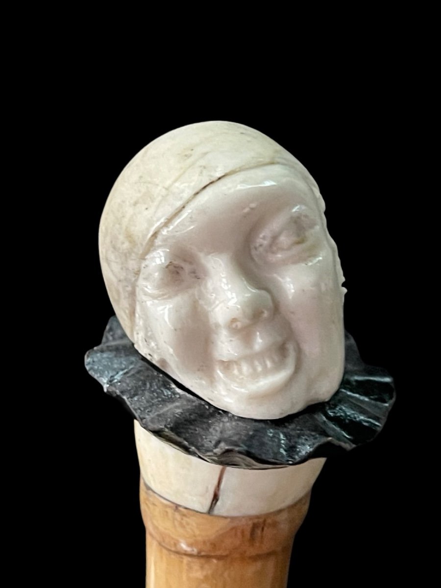 bastone con pomolo in avorio e ebano raffigurante testa di Pierrot con espressione  grottesca.