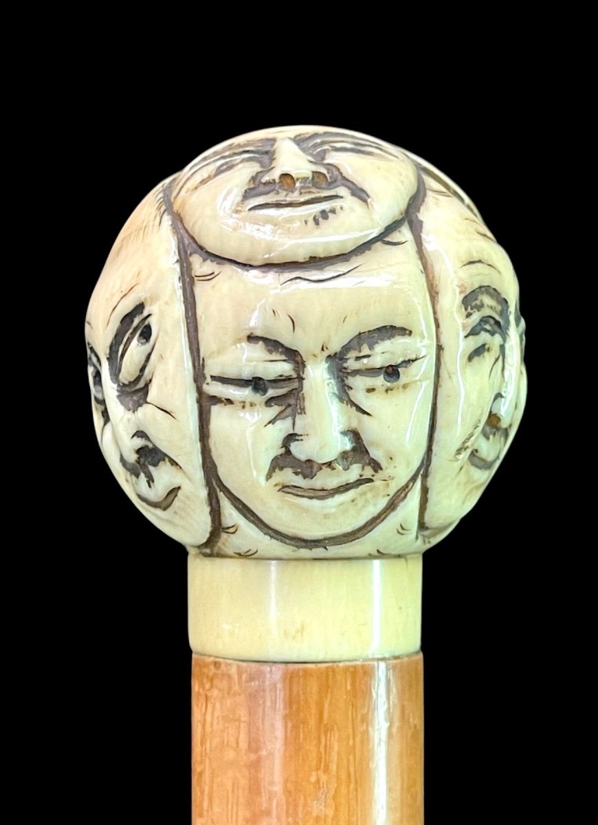 Bastone con pomolo tondo in avorio scolpito con maschere della commedia dell’arte.Giappone.