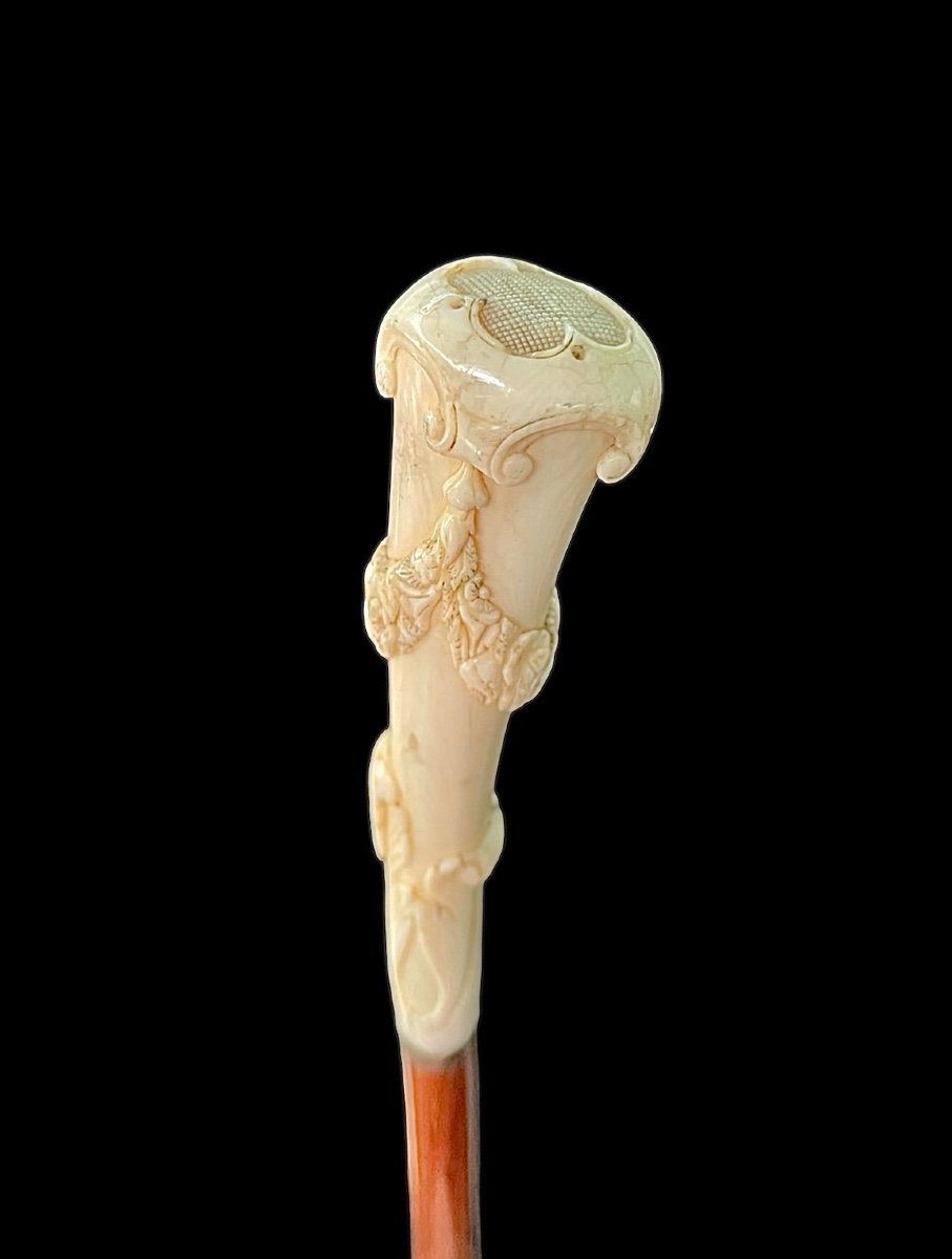 Bastone con pomolo verticale arcuato in avorio con incisione a festoni floreali e rocaille.