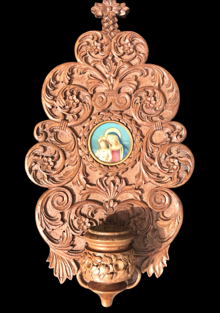 Acquasantiera in legno scolpito con motivi vegetali stilizzati e volute rocaille.