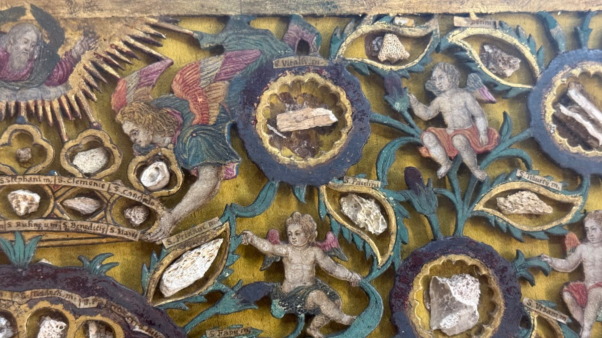 Quadro reliquiario con composizione in legno traforato in rilievo con putti e motivi vegetali.-photo-1