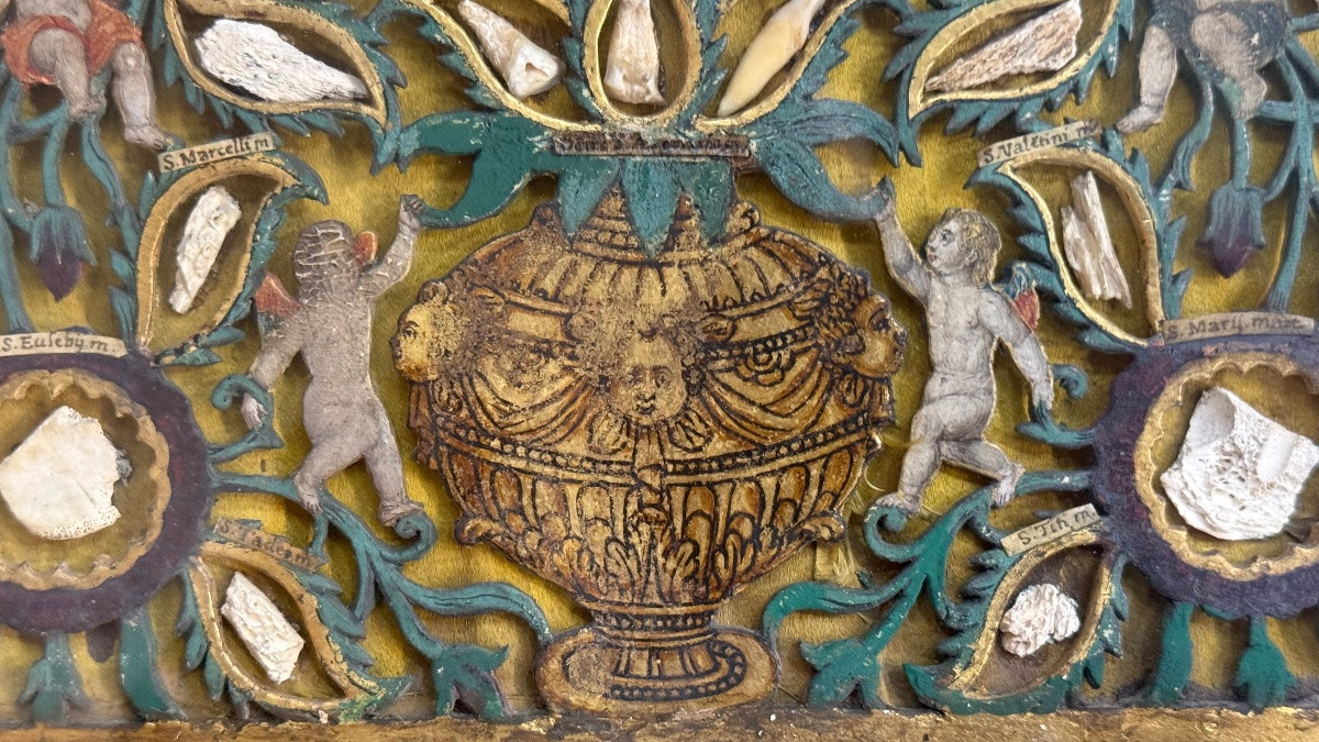 Quadro reliquiario con composizione in legno traforato in rilievo con putti e motivi vegetali.-photo-3