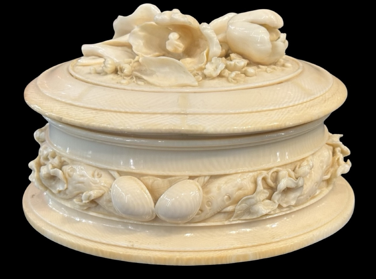 Scatola di forma ovale in avorio  lavorata a bassorilievo con motivi vegetali e  floreali.