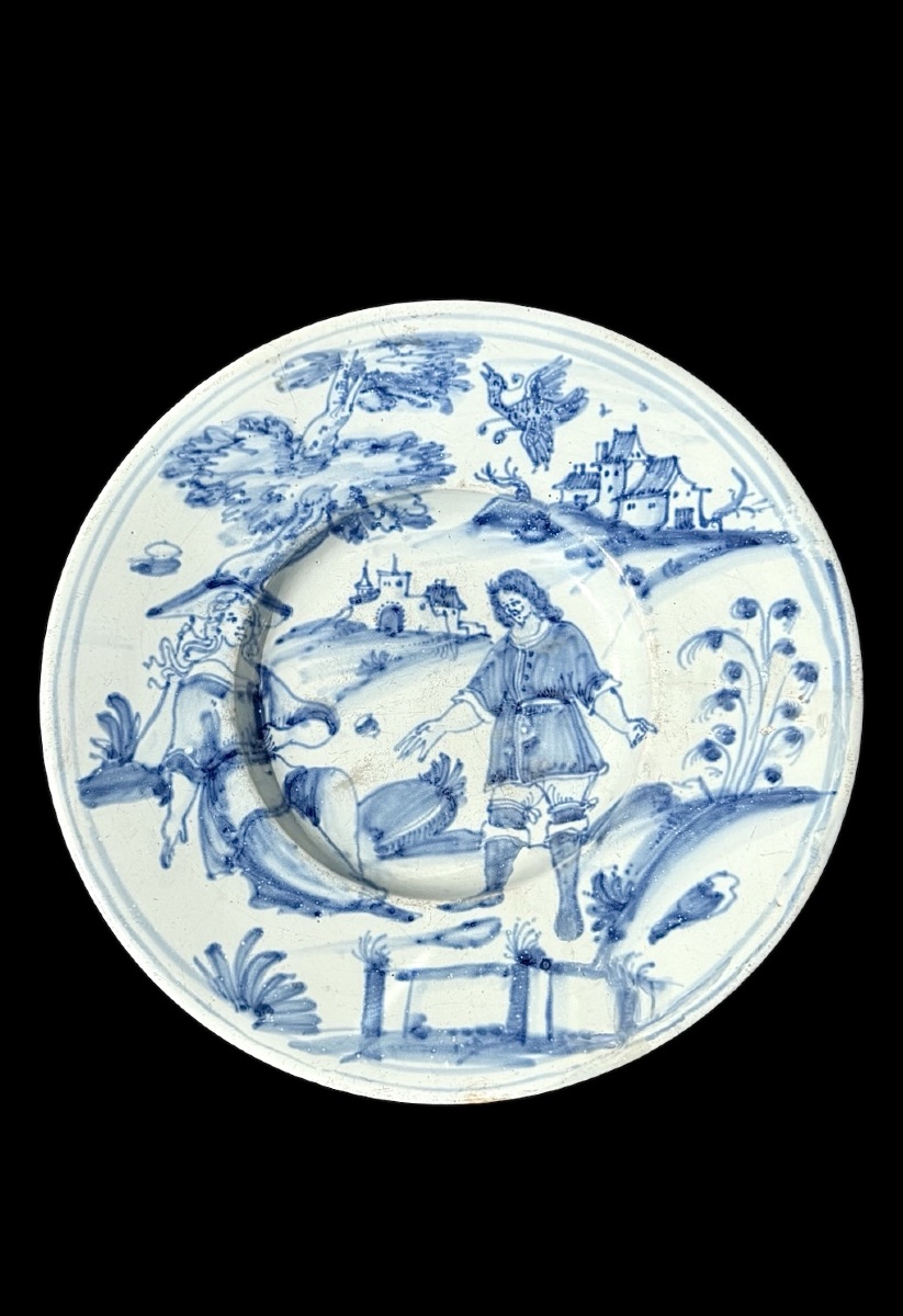 Piatto in maiolica in monocromia turchina con coppia di personaggi in ambiente agreste.Nevers