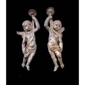 Coppia di candelieri-applique in rame argentato raffigurante angeli.