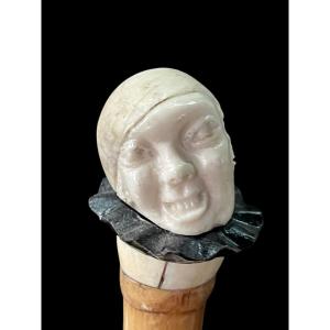 bastone con pomolo in avorio e ebano raffigurante testa di Pierrot con espressione  grottesca.