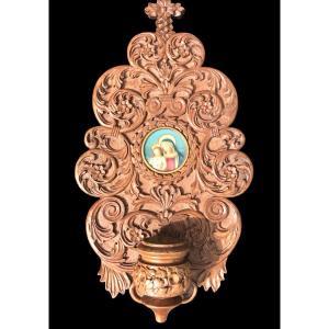 Acquasantiera in legno scolpito con motivi vegetali stilizzati e volute rocaille.
