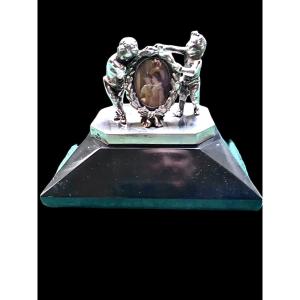 Fermacarte  press-papier in argento massiccio  con due putti che sostengono un portaritratti 