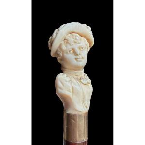 Bastone con pomolo in avorio raffigurante busto femminile con cappello.
