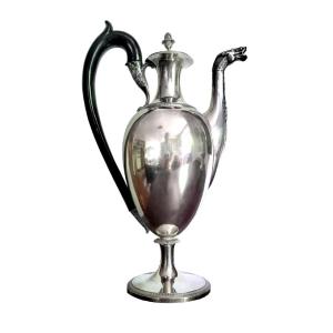 Caffettiera in argento a corpo piriforme su base circolare profilata da foglie lanceolate.