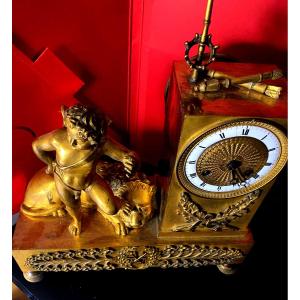 Mantel Clock With A Reclining Winged Lion Cupid, Charles X Period, In Gilt Bronze With An Enamel Dial