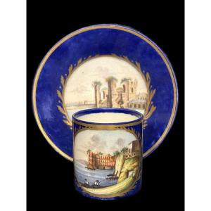 Tazza e piattino in porcellana, fondo blu e oro decorato a paesaggio, Manifattura Giustiniani