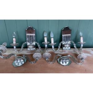 4 Twisted Glass Sconces On A Mirror Background