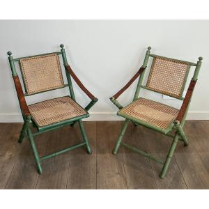 Pair Of Folding Safari Chairs In Patinated Faux Bamboo, Caned Backs And Seats And Leather Arms