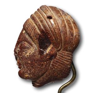 An Etruscan Amber Head Pendant. Etruria, Circa 5th Century B.c.