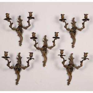 Gruppo di cinque applique a due luci in bronzo. XIX secolo