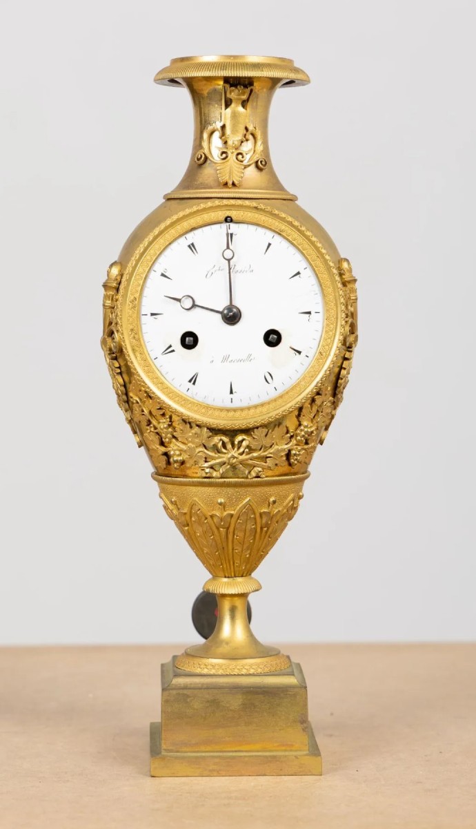 Pendola in bronzo dorato decorato con foglie e tralci di vite. Impero, XIX secolo