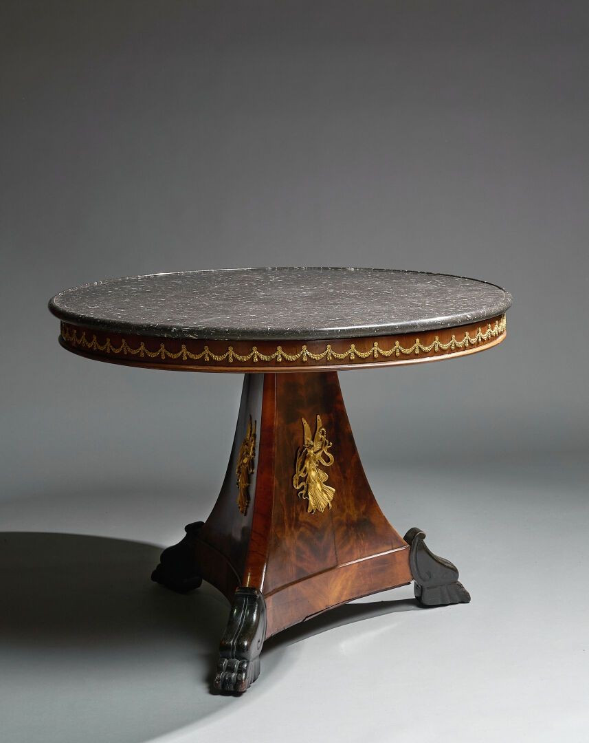 Tavolo impiallacciato in mogano. Piano circolare sormontato da marmo nero, XIX secolo.