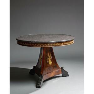 Tavolo impiallacciato in mogano. Piano circolare sormontato da marmo nero, XIX secolo.
