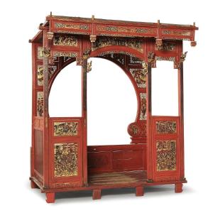 Grande letto a baldacchino in legno laccato rosso e oro, decorato con pannelli laccati. Cina, d