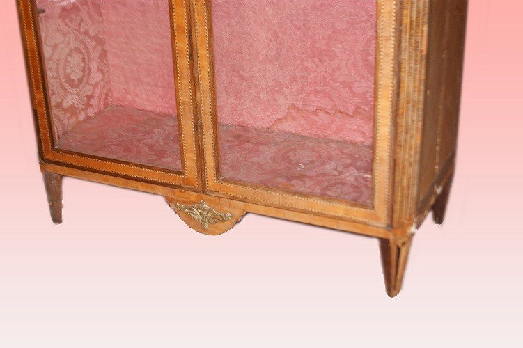 Stupenda vetrinetta francese di metà 1800,  in legno di mogano. Presenta 2 ante a vetro con motivi di intarsio sul fronte sui fianchi e sul piano superiore; piedini a piramide rovesciata e applicazioni in bronzo.   Prezzo compreso di rest-photo-3