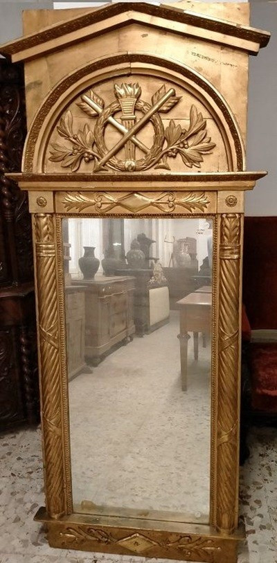 Specchiera in legno intagliato e dorato. Presenti montanti laterali a colonna mentre la ricca 