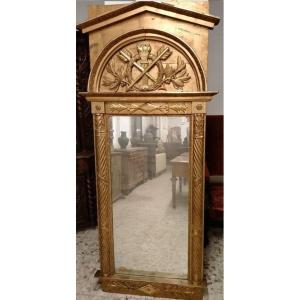 Specchiera in legno intagliato e dorato. Presenti montanti laterali a colonna mentre la ricca 