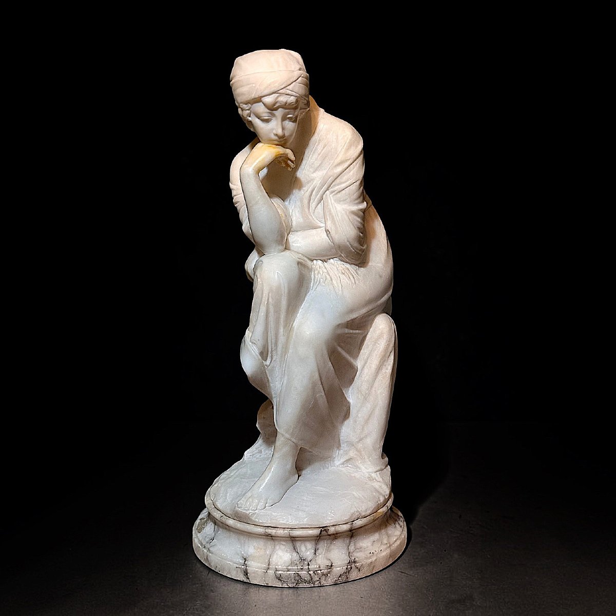 Statua raffigurante una giovane fanciulla con mano al mento 