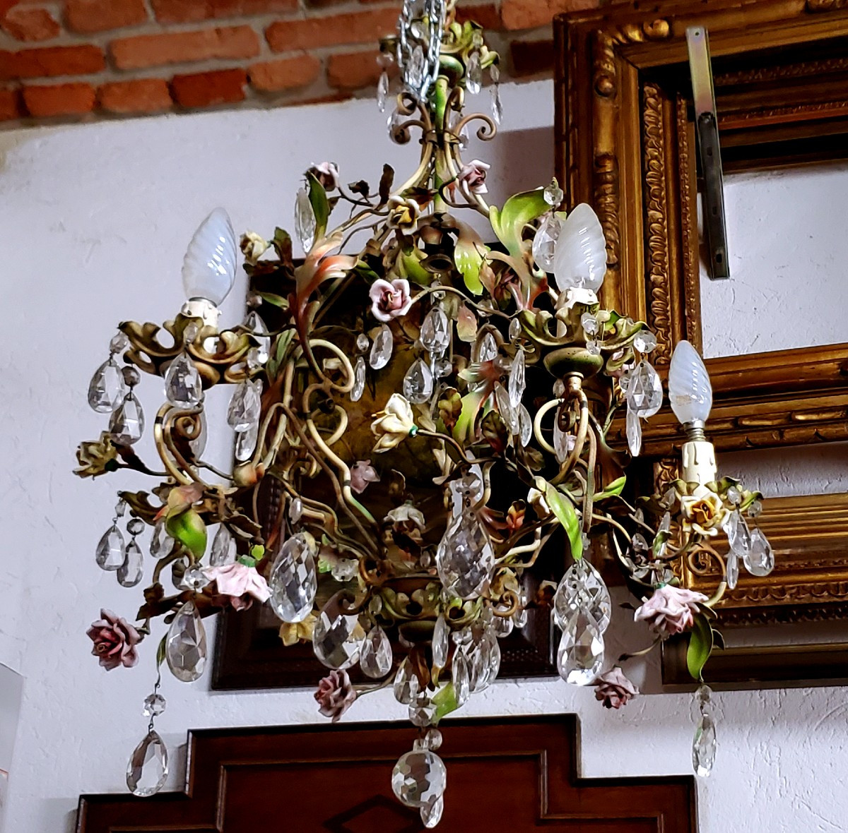 Lampadario in ferro battuto e decorazioni di foglie in lamierino e fiori in porcellana