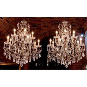 Coppia di grandi lampadari in ferro dorato con ricchissima decorazione in cristallo