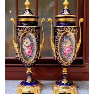 Coppia di vasi in porcellana blu cobalto con decorazioni dorate in rilievo e miniature floreali