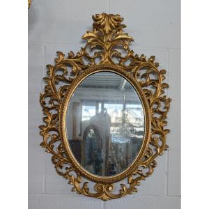 Specchiera ovale fiorentina in legno scolpito e dorato a oro zecchino – metà XIX secolo