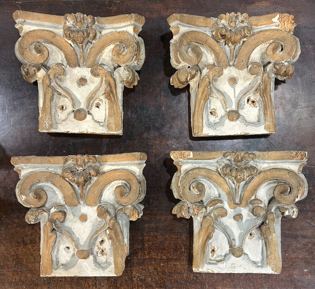 Gruppo di 4 capitelli in legno laccato elemento da boiserie tardo barocco, primi XVIII secolo.
