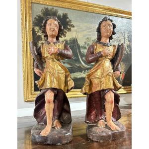 Coppia di sculture in legno raff. figure allegoriche che reggono cornucopia. Italia, XVII s.